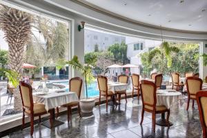 a restaurant with tables and chairs and large windows at Al Khalidiah Resort in Sharjah