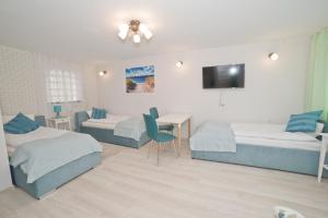 ソポトにあるLa Playa by Grand Apartmentsのベッドルーム1室(ベッド2台、デスク、テレビ付)