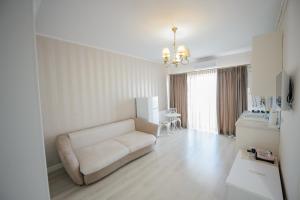 a white living room with a couch and a table at Complex Bavaro in Mamaia Sat/Năvodari