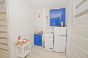 ソポトにあるLa Playa by Grand Apartmentsの白いキッチン(冷蔵庫、テーブル付)