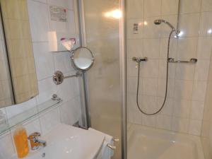 a bathroom with a shower and a sink and a toilet at Hotel-Restaurant zum Roeddenberg in Osterode +19 photos