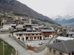a group of buildings in a village with mountains at Bapsha Guesthouse in Mestia