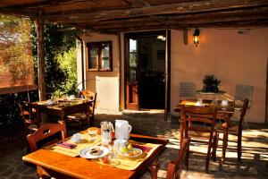 una zona de comedor al aire libre con mesas y sillas de madera. en Il Gaggiolo, en Rispescia