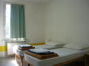 Ostello Domus Augusta Aquileia tesisinde bir odada yatak veya yataklar
