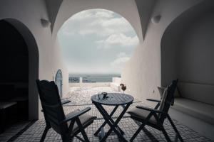 イメロヴィグリにあるLa Maltese Private House Imerovigliの椅子2脚、テーブル、窓が備わる客室です。