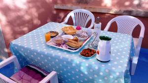 a white polka dot table with breakfast food on it at Azur Tafraout in Tafraoute