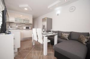 una cucina e un soggiorno con tavolo e divano di Apartment Slad a Kaštela (Castelli) Altre 25 foto