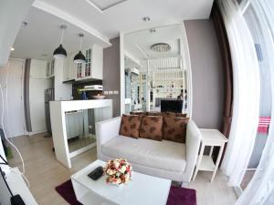 邦賢的住宿－The Patio Bangsaen，客厅配有白色的沙发和桌子