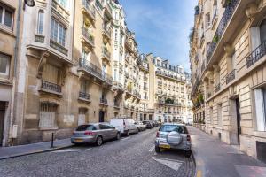 a street with cars parked on the sides of buildings at CMG Trocadéro/ Passy in Paris