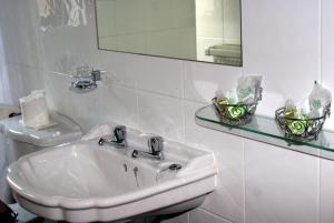 a white bathroom with a sink and a mirror at Bowood Park Hotel in Camelford