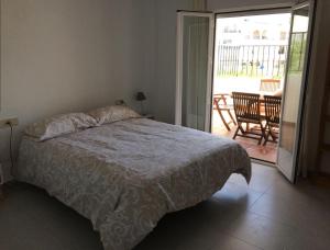 a bedroom with a bed and a door to a patio at Apartamento Elia Villa África in Aguadulce