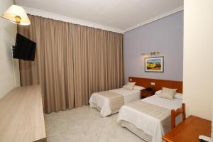 Postel nebo postele na pokoji v ubytování Hotel Complejo Los Rosales