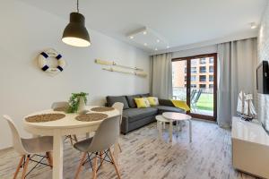 een woonkamer met een tafel en een bank bij Apartinfo Aura Island in Gdańsk