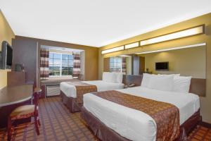 a hotel room with two beds and a table at Microtel Inn & Suites by Wyndham Harrisonburg in Harrisonburg