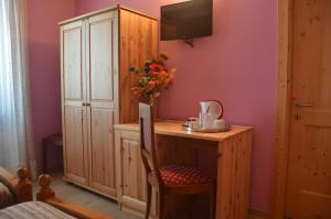 a room with a desk with a vase of flowers at Affittacamere Porticciolo in Castelnuovo del Garda
