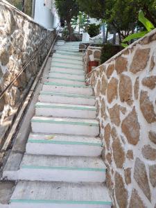 un escalier à côté d'un mur en pierre dans l'établissement Casa Costa Brava, à Acapulco
