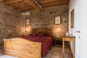 a bedroom with a bed and a dresser at Il Chiostro Appartamenti & Suites in Suvereto