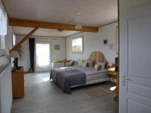 Schlafzimmer mit einem Bett, einem Schreibtisch und einem Fenster in der Unterkunft Redspring Chambres d'Hôtes in Coligny