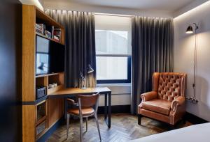 ロンドンにあるザ ホクストン ショーディッチのデスクと椅子が備わるホテルルームです。