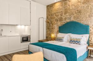 ein Schlafzimmer mit einem großen Bett mit blauem Kopfteil in der Unterkunft 296 Heritage Apartments in Vila Nova de Gaia