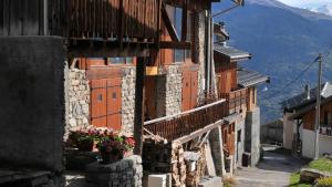 a building with a balcony and flowers on a street at alpes studio in Feissons-sur-Salins