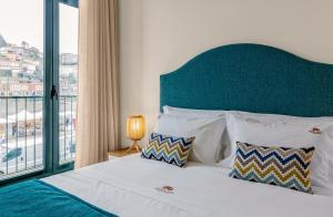 um quarto com uma cama com uma cabeceira verde e uma janela em 296 Heritage Apartments em Vila Nova de Gaia