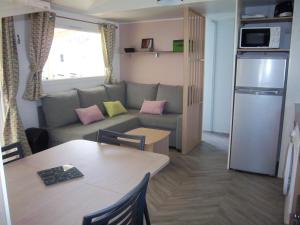 a small living room with a couch and a table at Les dunes de contis- landes in Saint-Julien-en-Born +10 photos