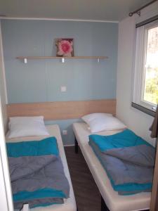 2 camas en una habitación con ventana en Les dunes de contis- landes, en Saint-Julien-en-Born