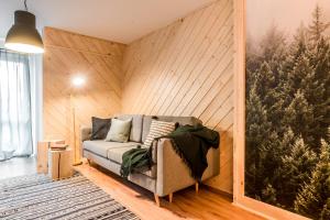 een woonkamer met een bank in een houten muur bij Kasprowy Wierch in Zakopane