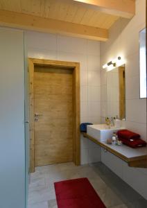 a bathroom with a wooden door and a sink at Feriendorf Berghof in Heiligen Gestade