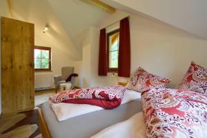 1 dormitorio con 2 camas y almohadas rojas y blancas en Feriendorf Berghof en Heiligen Gestade