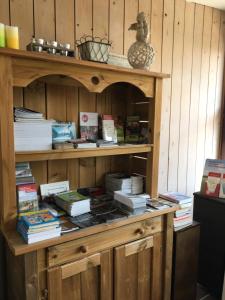 a wooden book shelf with books on it at 'T Wolvennest in Heuvelland