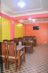 an empty dining room with wooden tables and chairs at Panorama Guest House in Nagarkot