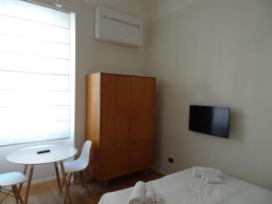 sypialnia z łóżkiem, stołem i telewizorem w obiekcie Grey Design Suite w Mediolanie