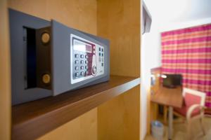 a microwave on a wooden shelf in a room at UNA HOTELS Cesena Nord in Cesena