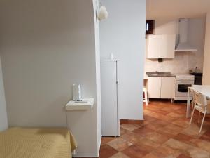 a small kitchen with a table and a white refrigerator at Iblea Paradise in Ragusa