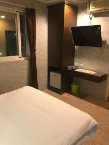 新竹市的住宿－棒球精緻旅店，一间卧室配有一张床和一台平面电视