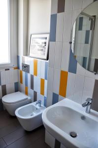 een badkamer met een wastafel, een toilet en een spiegel bij Tortona86 in Milaan