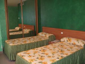 Habitación con 2 camas y espejo. en Hotel Vadorrey, en Roa