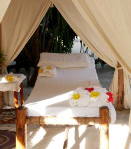 a bed in a tent with towels on it at Sea View Lodge Boutique Hotel in Jambiani