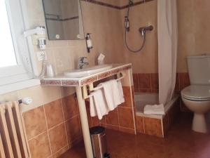 Un baño con lavabo, inodoro y ducha. en Hôtel Evian Express - Terminus, en Évian-les-Bains