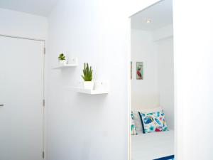 a white room with a mirror and a couch at Cantinho das Flores I in Nazaré