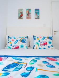 a bed with colorful sheets and pillows on it at Cantinho das Flores I in Nazaré