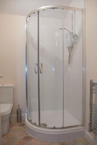 a shower stall in a bathroom with a toilet at The Blacksmiths Arms in Penistone