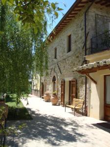 un bâtiment en pierre avec un banc devant lui dans l'établissement Fattoria Il Bruco, à Pila