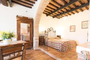 een slaapkamer in een villa met een bed en een tafel bij Fattoria Il Bruco in Pila