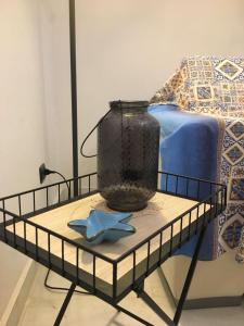 a vase on a table next to a bed at La Casa Dell'Amore Perfetto in Genova