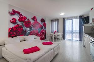 sypialnia z dużym łóżkiem z czerwonymi poduszkami w obiekcie Sea Star Kabakum Apartments w Złotych Piaskach