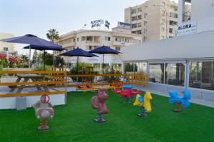 a patio with colorful plastic animals on the grass at Alora Apartments in Larnaca