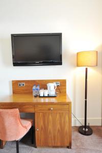 Habitación con escritorio y TV en la pared. en Alexander Thomson, en Glasgow